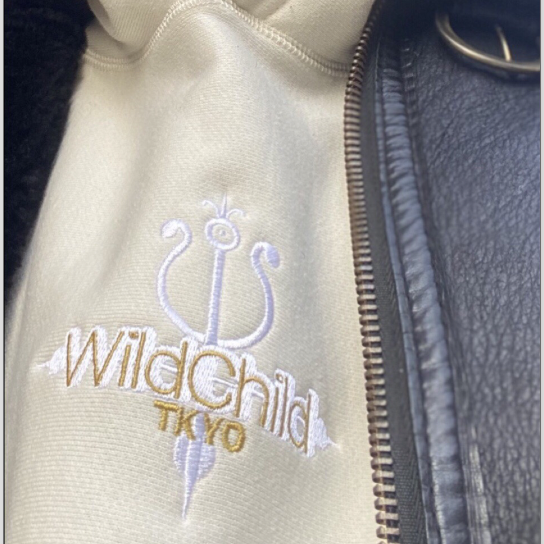 Creamy off white heavyweight hoodie with embroidered WildChild TKYO logo in Ice White & Gold, styled with a black shearling leather American military flight jacket